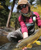 An angler shows off a brown trout.